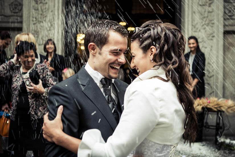 Fotografo matrimonio Torino: due sposi sorridono durante il lancio del riso