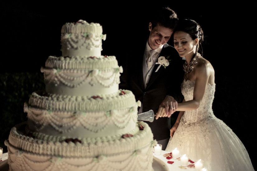 Fotografo matrimonio Torino: due sposi sorridono mentre tagliano la torta