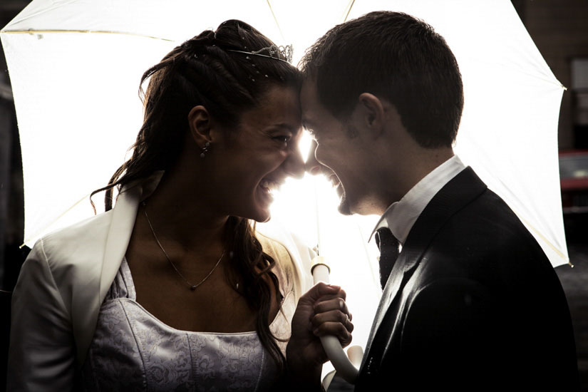 Fotografo matrimonio Torino: felicità di due sposi che si sorridono sotto un ombrello