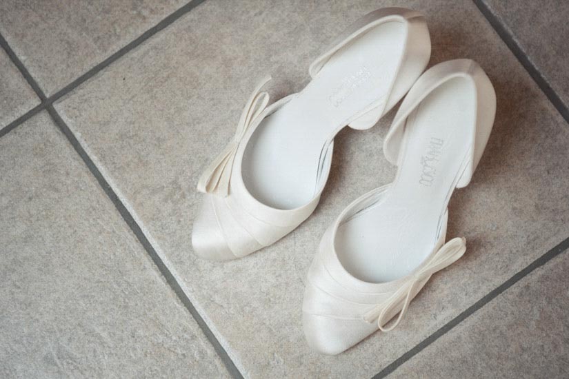 Fotografo matrimonio Torino: due scarpe bianche per un vestito da sposa a Pecetto